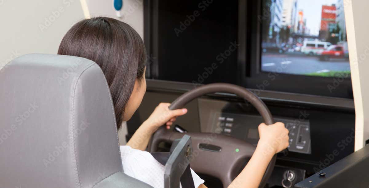 運転シミュレーターで自動車運転の評価を受ける女性