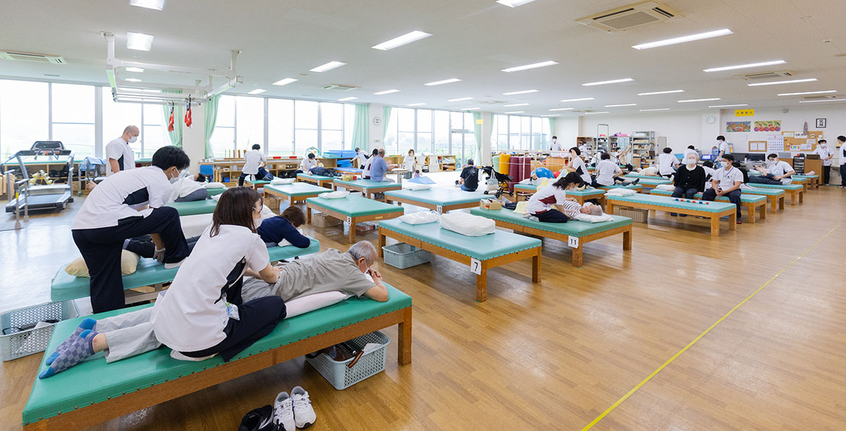 車椅子の利用者の足を診察する医師